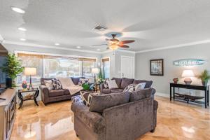 a living room with two couches and a ceiling fan at Clearwater Calling in Clearwater Beach