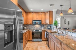 a kitchen with wooden cabinets and stainless steel appliances at Clearwater Calling in Clearwater Beach