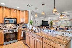 a large kitchen with wooden cabinets and a counter top at Clearwater Calling in Clearwater Beach +16 photos