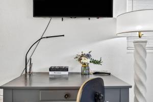 a desk with a lamp and a vase of flowers on it at Buffalo Bungalow in Clearwater Beach +34 photos