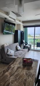 a living room with a couch and a large window at Cozy and Modern in Cancún