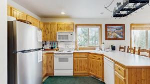 a kitchen with wooden cabinets and a refrigerator at Spring Mountain Condo Pool Gym Slopes in McCall