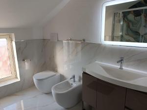 a bathroom with a toilet and a sink and a mirror at Maison MariEtt - Smart & Living Suites - in Troia +43 photos