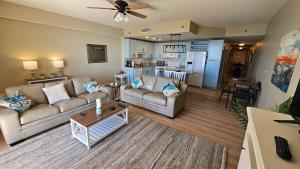 a living room with two couches and a kitchen at Stunning Gulf View Condo - Direct Beach Access - Stunning Sunsets in Panama City Beach