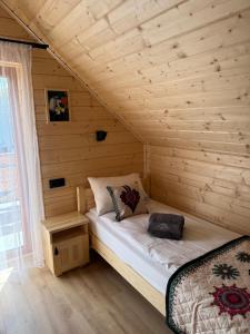 a bedroom with a bed in a wooden cabin at Frankowe Domki in Szczawnica