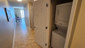 a kitchen with a washer and dryer in a room at Stunning Gulf View Condo - Direct Beach Access - Stunning Sunsets in Panama City Beach