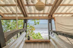 a room with hammocks looking out at the ocean at El Vijo Surf in Nuquí