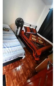 a bedroom with a bed and a wooden floor at Quarto privativo in Telêmaco Borba