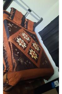 a cake shaped like a bed with flowers on it at Quarto privativo in Telêmaco Borba