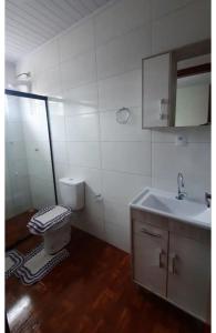 a bathroom with a sink and a toilet at Quarto privativo in Telêmaco Borba