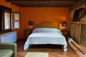 a bedroom with a bed in an orange wall at Molino del Medio Apartamentos Rurales in Robledillo de Gata