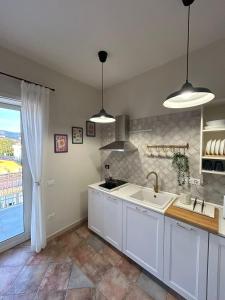 a kitchen with white cabinets and a sink and a window at DIMORA REALE - Charming House Caserta in Casagiove