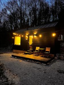 a cabin with two chairs and a table on a deck at TogetherNest - Ash in Mătişeşti