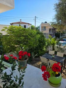 a patio with a table with red flowers on it at Sun & Moon Studio Afitos in Afitos