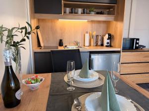 a kitchen with a dining table with a bottle of wine at Mobile House Aurora with whirlpool in Ankaran