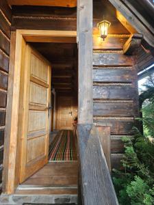 an entrance to a wooden house with a door at Chalupa pod Skleným Vŕškom in Huty
