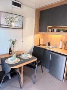 a kitchen with a table and a sink at Mobile House Aurora with whirlpool in Ankaran +22 photos