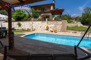 a swimming pool in front of a house at Villa Mountain with Pool in Gedeller