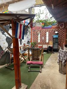 a man sitting at a table under an umbrella at Wally's House Mancora in Máncora