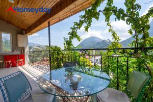 a glass table on a balcony with a view of mountains at Villa Mountain with Pool in Gedeller