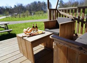 a wooden deck with a table and two bottles of beer at F1 Weekend House Close to Spa 6 Guests Doc in Amblève
