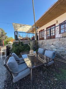 a glass table and chairs in front of a building at Casona san isidro in Vicuña