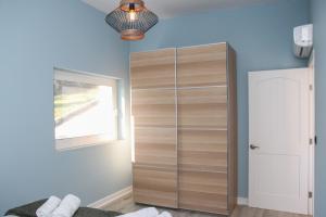 a bedroom with a large wooden closet with a window at Zeus Cosmos Apartments in Lourdata +240 photos