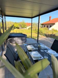 a table with plates and napkins on a patio at Mobile House Aurora with whirlpool in Ankaran