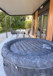 a mattress on a patio with a table and chairs at Mobile House Aurora with whirlpool in Ankaran