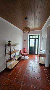 a living room with a wooden ceiling and a red chair at ALgarvia in Algarvia