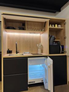 an open refrigerator in a kitchen with a sink at Spa Signature in Dijon
