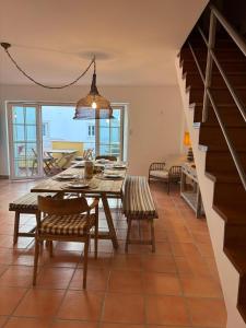 a dining room with a table and chairs and a staircase at Ria Seahouse Cabanas de Tavira in Tavira