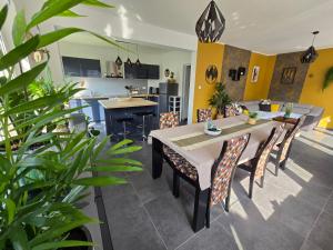 a dining room and kitchen with a table and chairs at Les Aurores Marines in Bray-Dunes