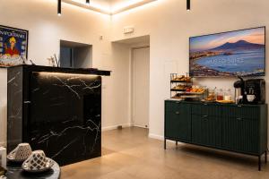 a kitchen with a black cabinet and a tv on the wall at Museo Suite in Naples