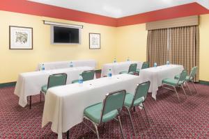 a conference room with tables and chairs and a flat screen tv at Ramada by Wyndham Vandalia in Vandalia