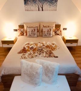 a bedroom with a large white bed with two tables at L Éden aux hirondelles & SPA in Samer