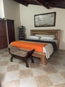 ein Schlafzimmer mit einem großen Bett und einer orangefarbenen Decke in der Unterkunft casa serrano in Valledupar