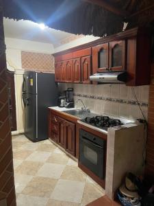 eine Küche mit Holzschränken und einem Herd und einem Kühlschrank in der Unterkunft casa serrano in Valledupar