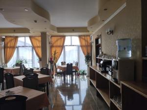 a dining room with tables and chairs and windows at RHC Royal Hotel in Oradea