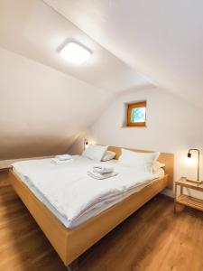 a bedroom with a large bed with white sheets at Silent Orchard in Naklo