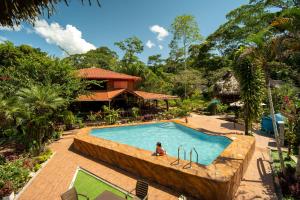 a person sitting in a pool at a resort at Suchipakari Amazon Eco -Lodge & Jungle Reserve in Puerto Misahuallí