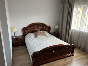 a bed in a bedroom with two tables and a window at Luxury Residence Akmenė in Akmenė