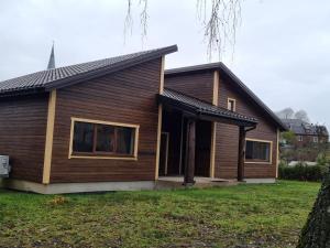 a wooden house with a gambrel roof at Luxury Residence Akmenė in Akmenė