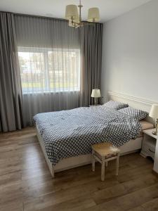 a bedroom with a bed and a window and a table at Luxury Residence Akmenė in Akmenė