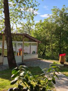 a small building with glass windows in a park at Бунгала ЛАГО in Gabrene