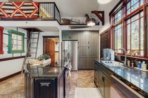 a large kitchen with a large counter and a staircase at Deer Haven Lodge in Kalispell