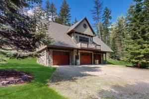 a house with red doors and a yard at Deer Haven Lodge in Kalispell