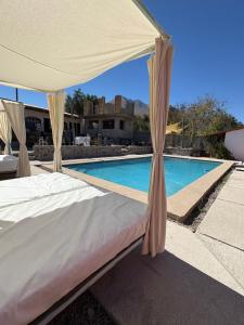 a bed with a canopy in front of a swimming pool at Casona san isidro in Vicuña