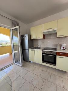 a kitchen with a stove and a refrigerator at Apartments Mikecin in Novigrad Dalmatia