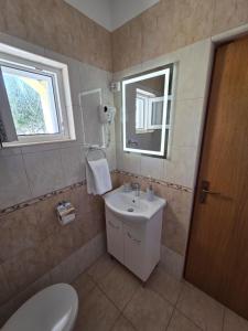 a bathroom with a sink and a toilet and a window at Apartments Mikecin in Novigrad Dalmatia +30 photos
